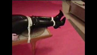 JADE TAPE GAGGED & BOUND TO COFFEE TABLE IN BLACK PVC CATSUIT & HIGH HEELED BOOTS 1